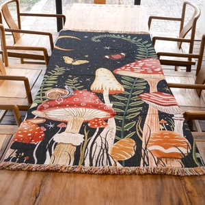 Vintage mushroom forest woven tapestry with rainbow fringe on a rustic wooden table