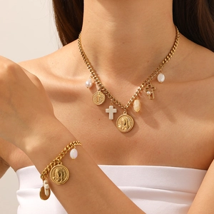Detail of vintage gold necklace and bracelet with cross pendant and pearl beads