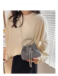 Detail of rhinestone bucket bag with metal ring handle and crossbody chain strap