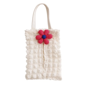 Detail of white bubble gauze tissue bag with a 3D floral accent for car seat backs