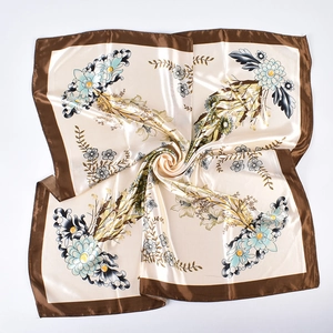Detailed swirl fold of square satin silk scarf with vintage floral print and brown border