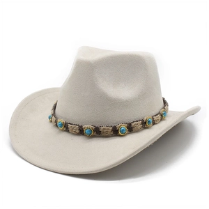 Détail du chapeau de cowboy crème avec ruban tressé marron et pierres turquoises déco