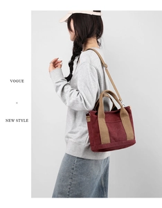 Close-up of burgundy canvas bag with beige handles and adjustable strap detail