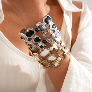 Close-up of bohemian wide metal bracelets with textured finish and decorative beads on wrist