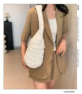 Détail d'un sac à bandoulière blanc matelassé avec texture bouffante plissée style nuage