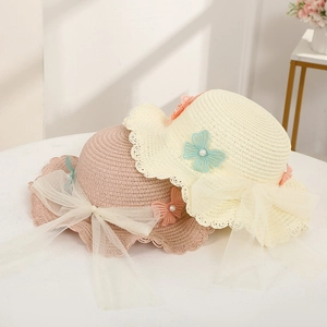 Close-up of woven straw sun hats featuring wave edges and delicate mesh butterfly bows