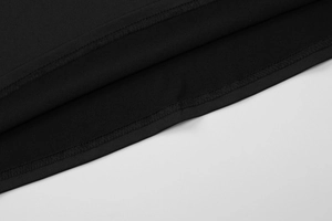 Dettaglio macro dell'orlo a doppia cucitura e della trama in maglia di un abito nero