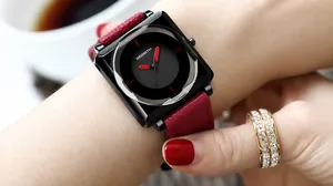 Close-up of a women's square quartz watch with red hands and deep red leather strap
