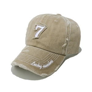 Detail of distressed vintage khaki baseball cap with number 7 embroidery and lucky numbers text