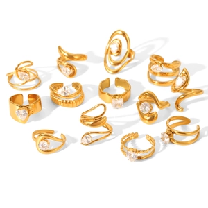 Set of 13 gold plated geometric rings with heart and round zircon stones on white background