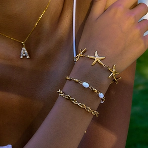 Golden titanium steel jewelry set with freshwater pearls and star charms on a female model