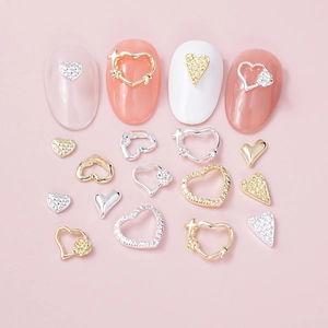 Detailed view of luxury heart nail charms in gold and silver for romantic DIY nail art