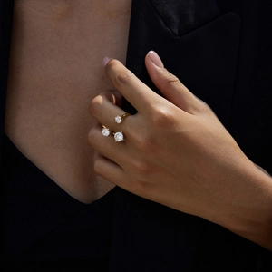 Detailed view of an asymmetric 16K gold branch ring with clear zircons worn by a model