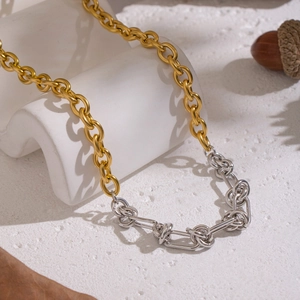 Zweifarbige Gold- und Silber-Edelstahl-Gliederkette auf weißem Kunsthintergrund