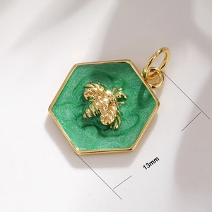 Detail of 13mm hexagonal green enamel bee pendant with gold-plated edges for jewelry making