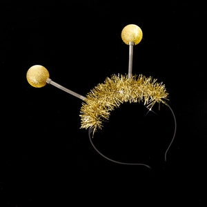 Detailed shot of golden antenna headband with spring glitter balls and sparkly tinsel fringe