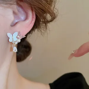Butterfly pearl drop earrings with zircon crystals on model for a sweet luxury look