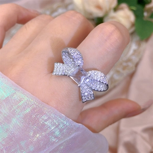 Close-up of zircon bow ring with a square center stone worn on a model's finger