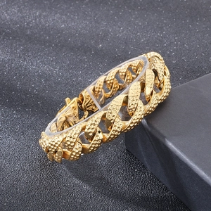 Detailed close-up of golden stainless steel cuban chain with vintage hammered texture clasp