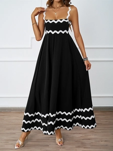 Detailed close-up of a black maxi dress featuring distinctive white wavy trim detailing