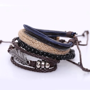 Detail eines mehrlagigen Lederarmband-Sets mit Silberfeder-Anhänger und Holzperlen