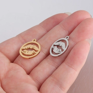 Close-up of gold and silver lip-shaped charms held in palm showing scale and detail