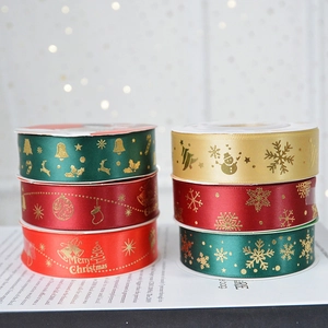 Merry Christmas satin ribbon rolls with gold foil lettering for holiday gift wrapping