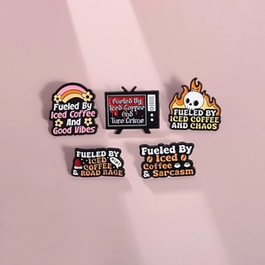 Five colorful enamel coffee badges featuring humorous iced coffee quotes on pink background