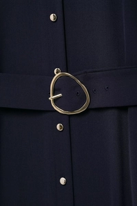 Detail of navy blue dress featuring unique gold buckle belt and metallic gold buttons