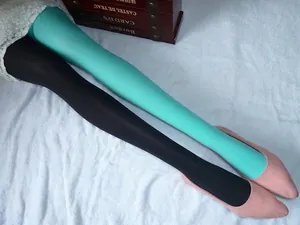 Détail de collants en velours bicolore bleu lac et noir avec des chaussures plates roses