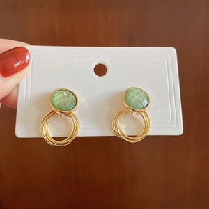 Boucles d'oreilles dorées avec résine ronde vert clair et trois anneaux pendants