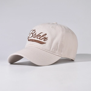 Detail shot of Brkln embroidery on beige cotton canvas baseball cap with curved brim