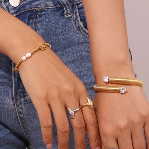 Close-up of 18K gold plated striped bracelet with heart zircon and pearl beads