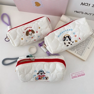 Detailed view of white quilted pencil cases with cute puppy embroidery and zipper