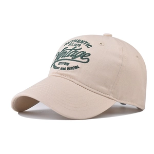 Vintage beige cotton baseball cap with green letter embroidery at a 45-degree angle