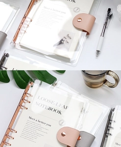 Close-up detail of transparent 6-hole PVC loose-leaf notebook cover with leather closure