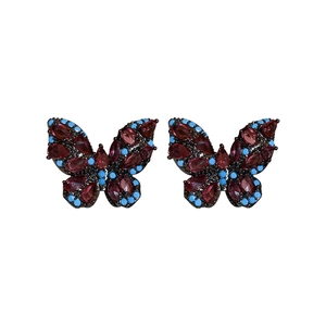 Vintage butterfly stud earrings with deep red rhinestones and blue beads on white background