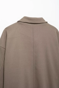 Detail of the back collar and central stitching on a brown wool coat with fine texture