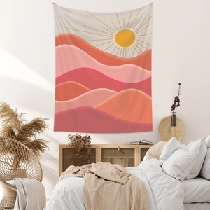 Detail of bohemian mountain tapestry hanging over bedroom wall with warm sunset patterns
