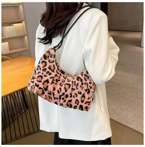 Dettaglio della borsa a spalla in peluche leopardata rosa su modella con completo bianco