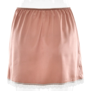 Détails d'une mini-jupe en satin rose avec bordure en dentelle blanche et texture soyeuse