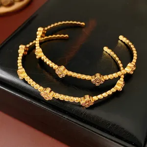 Eleganti bracciali aperti placcati oro 18k con motivi a quadrifoglio e zirconi lucenti