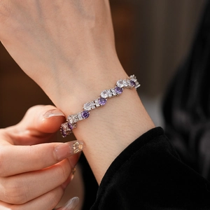 Detailed view of silver bracelet with purple and white cubic zirconia on a wrist