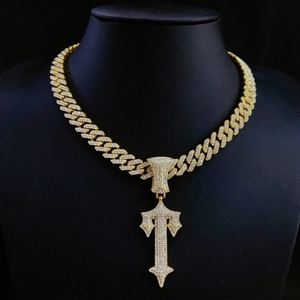 Gold-plated hip hop Cuba chain with iced out cross sword pendant on a black mannequin