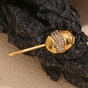 Detail of 18K gold-plated egg-shaped hair clip with sparkling rhinestone inlay