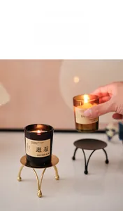 Detail of minimalist gold and black iron candle tray with three-leg ball base design