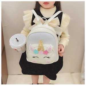 Detail of white unicorn backpack featuring gold horn and colorful sequin stars decorations