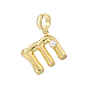 Vue macro du pendentif lettre M doré avec perle blanche et finition en métal poli brillant