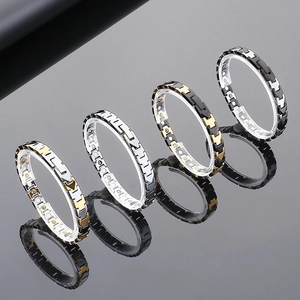 Detail of magnetic tungsten steel bracelets in four colors on a gray mirror surface