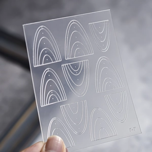 Close-up of F-7 nail art stencil with concentric arc patterns and transparent texture